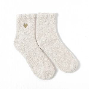 Detail of white coral fleece sleep socks featuring delicate gold heart embroidery