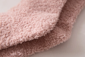 Close-up of soft pink coral fleece fabric showing high-density plush texture on cozy socks