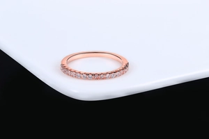 Detail of rose gold plated ring with micro-pave cubic zirconia on white stand