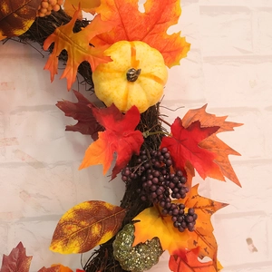 Autumn wreath with maple leaves pumpkins and berries on rustic grapevine base