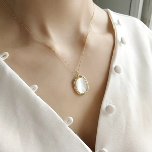Elegant 925 sterling silver gold necklace with oval mother of pearl shell pendant on model