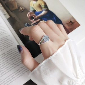 Vintage 925 sterling silver cross ring on finger with artistic classic painting background