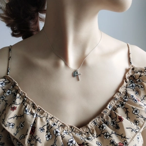 Detail of vintage 925 sterling silver cross and oval religious medal pendant necklace