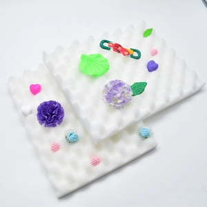 Macro shot of white wave foam pads for fondant drying with colorful sugar flower decorations