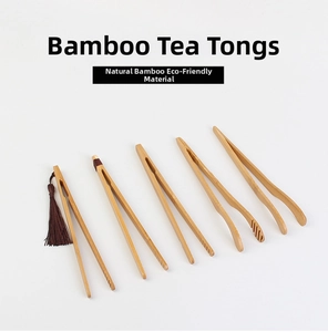 Set of five natural bamboo tea tweezers with a decorative dark brown tassel on white background