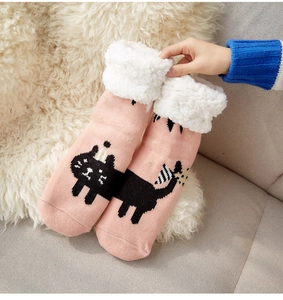 Detail of pink knitted thermal socks with cute cat pattern and thick fleece lining