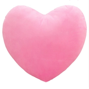 Close-up of a soft pink heart-shaped plush pillow with a fuzzy texture on white background