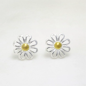 Detailed view of silver daisy stud earrings with golden center on white background