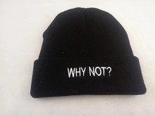 Detail of black knitted beanie featuring white WHY NOT? embroidery on high-quality fabric
