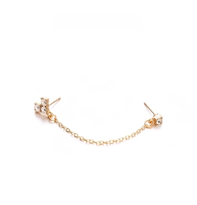 Detail of gold chain earring with crystal clusters on a minimalist white background
