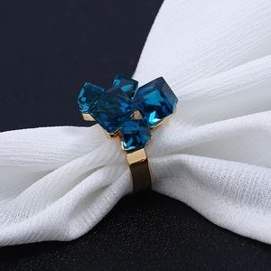 Dettaglio dell'anello dorato con quattro cristalli cubici geometrici blu scuro