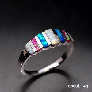 Polished silver ring featuring colorful inlaid opal stones in pink, blue and white hues