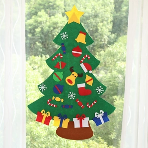 DIY felt Christmas tree with colorful ornaments attached to a glass window with curtains