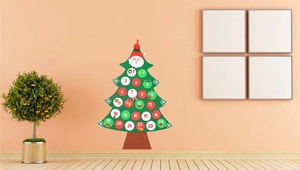 Detail of green felt Christmas tree countdown calendar with numbered 1-24 gift pockets
