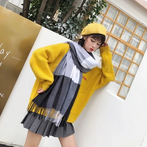 Winter outfit detail featuring black and white plaid fringed scarf with yellow sweater