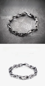 Macro detail of men's mechanical link bracelet with polished silver finish and secure clasp