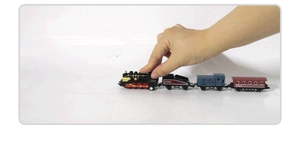 Detailansicht einer Hand, die eine Vintage-Dampflokomotive hält, um die Größe zu zeigen