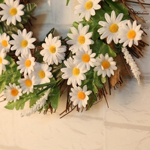 Handcrafted white daisy floral wreath with green leaves on natural branch vine base