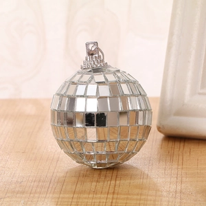 Close-up of a reflective silver disco mirror ball with metallic hanging loop on wooden table