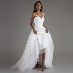 Détails d'une robe de mariée blanche en tulle high-low avec décolleté en cœur et fines bretelles