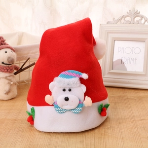 Detail of red Christmas hat featuring a plush white bear ornament and red berry accents