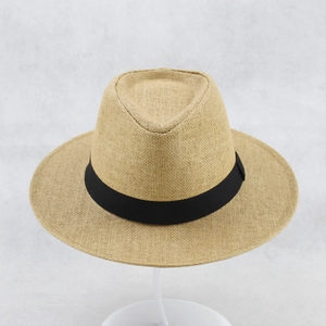 Detail of classic khaki straw sun hat with black ribbon and tight weave texture