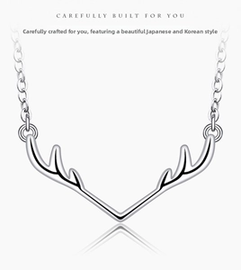 Macro shot of polished elk antler pendant with fine chain on minimalist background