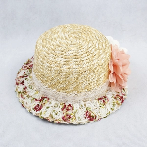 Detailed straw sun hat showing delicate white lace trim and floral rose decorations