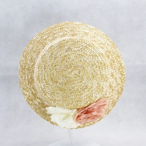 Detailed top view of natural straw boater hat with delicate pink and white mesh flowers