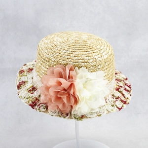 Macro detail of hand-woven straw hat featuring exquisite tulle flowers and floral embroidery