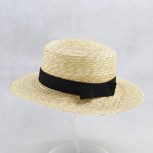 Elegant straw sun hat with flat top and black ribbon bow for summer beach wear