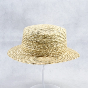 Detailed close-up of the woven texture and flat top design on a natural straw boater hat