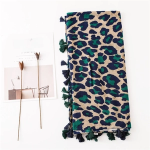Close-up of blue and dark green leopard print scarf with delicate handmade tassels
