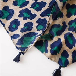 Detail of leopard print cotton linen scarf with blue tassels and woven texture