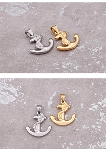 Detailed view of silver and gold anchor pendants with rope texture on stone surface