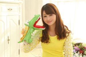Detailed view of a green plush crocodile hand puppet with a bright red open mouth