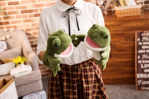 Detail showing plush green frog hand puppets with soft fabric and large expressive eyes