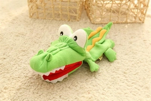 Close-up of soft green crocodile hand puppet plush with yellow scales for storytelling