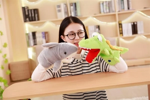Detailed view of shark and crocodile plush hand puppets being used for storytelling