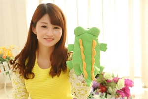 Detail of green plush crocodile hand puppet with soft fabric and orange spikes