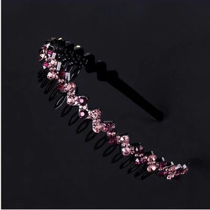 Detail of non-slip wavy headband with pink rhinestones and teeth on black base
