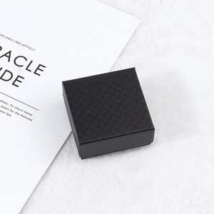 Top view of a square black jewelry gift box featuring a textured diamond pattern surface