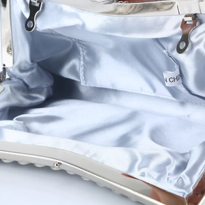 Interior detail of light blue evening clutch bag with satin lining and silver metal frame
