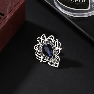 Macro shot of retro silver ring with pear-cut deep blue gemstone and diamond halo