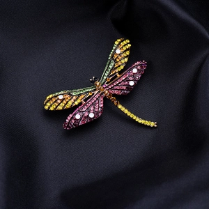 Elegant dragonfly brooch with colorful rhinestones on black textured silk background