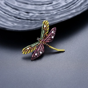 Close-up of vintage dragonfly brooch with multi-colored rhinestones and black metal base