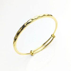 Detail of 18K gold plated bracelet featuring a faceted surface and adjustable slider design