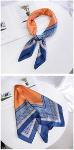 Nahaufnahme eines Seidenschals mit floralem Muster in Orange und Marineblauem Design