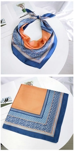 Detail eines seidigen blau-orangen Halstuchs mit Blumenmuster auf einem Display
