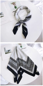 Detail eines Seidenschals mit Blumen- und Leopardenmuster und eleganter Bindung